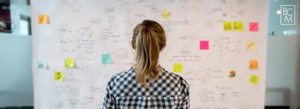woman looking at a white board with intricate planning