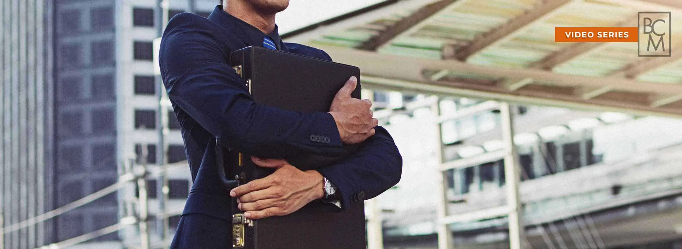 man in suit hugging briefcase